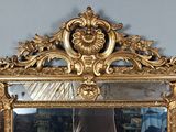 un miroir doré accroché au mur d'une pièce