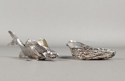 une paire de figurines de poissons en argent posées sur un support gris