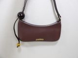 the brown purse is hanging on the wall next to a white wall