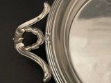 a silver tray with a handle on a black table