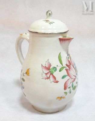 a small white tea pot with a flower design on it