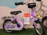 a purple bike that is parked in front of a wall