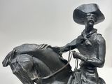 statue of a man riding a horse with a hat on his head
