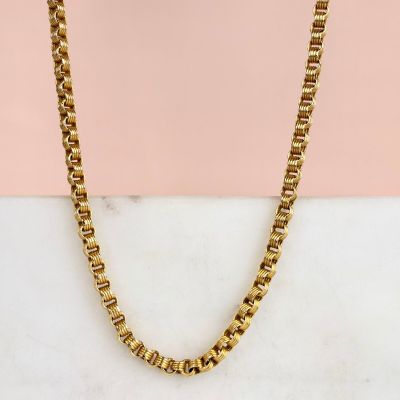 une photo d'un collier à chaîne en or posé sur une surface en marbre