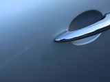a close up of a door handle on a silver car
