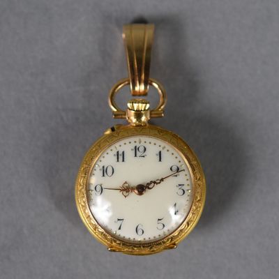 a small gold pocket watch with a white face