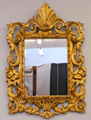 a gold mirror hanging on the wall in a room