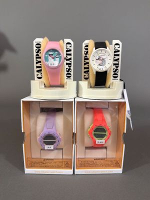 trois montres sont présentées dans un présentoir posé sur une surface grise