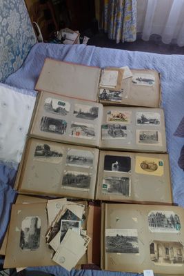 plein de vieilles photos posées sur un lit recouvert d'une couette bleue