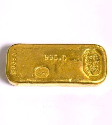 gros plan d'un lingot d'or sur une surface blanche