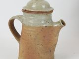 a coffee pot with a lid sitting on a white surface