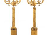 une paire de chandeliers anciens en laiton sur socles, sur fond blanc