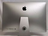 a silver apple computer sitting on top of a white table