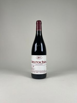 une bouteille de vin rouge posée sur une table blanche
