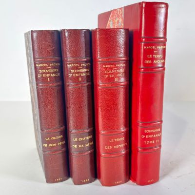 four red books are lined up in a row on a white surface