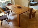 a wooden table with a bowl on it in the middle of a room