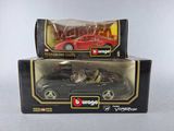 two toy cars are in a box on a white surface