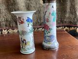 two vases that have flowers in them on a table