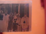 someone holding up a photo of a group of people in front of a window
