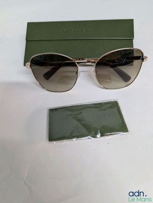 the sunglasses are sitting on the table next to a green box