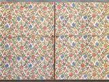 two pieces of fabric with a floral pattern on them on a gray surface