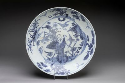 une assiette bleue et blanche décorée d'oiseaux et de fleurs