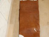 a long brown and white cow print bench in a bathroom