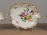 three plates with flowers on them sitting on a table