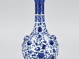 blue and white vase with flowers and leaves on a white background