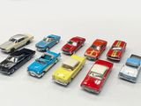 several toy cars are lined up in a row on a white surface