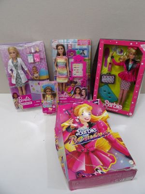 several barbie dolls are sitting on a table in front of a box