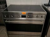 a stove and oven in a kitchen with tiled walls