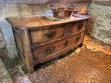 a wooden dresser with a metal bowl on top of it