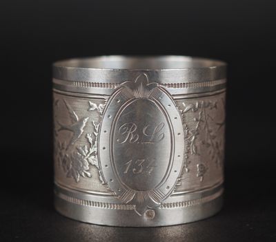 gros plan d'une bague en argent sur une surface noire