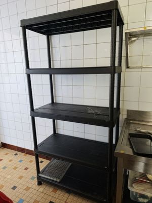 a black shelving in a kitchen with a sink and a stove