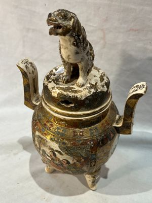 une théière en argent et or avec un chien sur le dessus