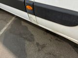 a white van with orange buttons parked in a parking lot