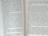 an open book sitting on top of a table next to a cup of coffee