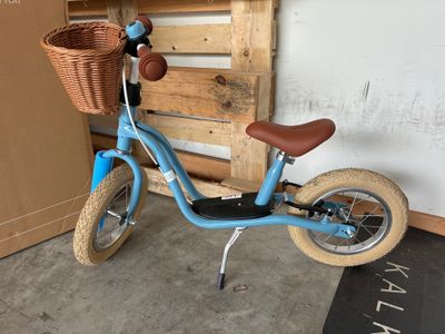 un petit vélo bleu avec un panier à l'arrière