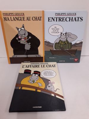 trois livres posés sur une table blanche, avec un chat et une souris