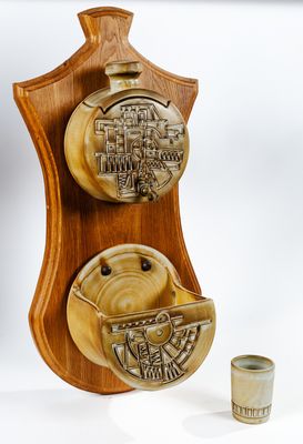 une plaque en bois sur laquelle figurent une théière et une tasse à côté