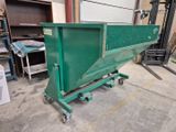 a green dumpster sitting in the middle of a garage