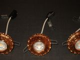 trois lampes plaquées cuivre, avec une lumière blanche au milieu
