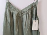 the back of a green top hanging on a wooden hanger