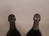 two bottles of wine sitting on top of a table next to each other