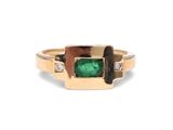 gros plan d'une bague en or avec une pierre verte et des diamants