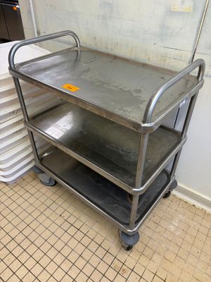 un chariot en métal posé au milieu d'un sol carrelé
