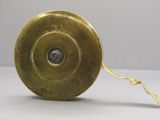 une image représentant un objet métallique doré posé sur une surface blanche