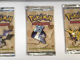 three packs of pokemon trading cards sitting on top of a counter