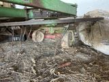 a green machine that is sitting in a pile of hay